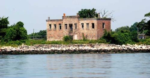 Civil War ruins on Hart Island surrounded by barbed wire.
